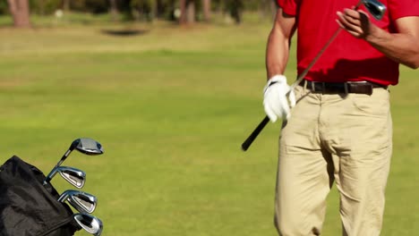Male-golfer-removing-golf-club-from-golf-bag-