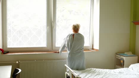 Senior-woman-standing-near-window