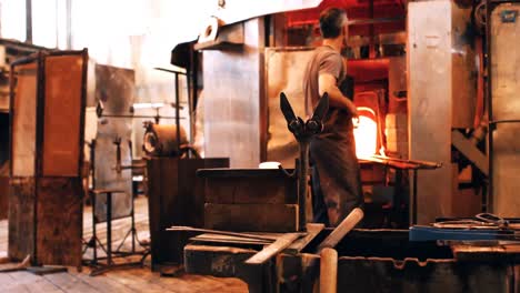 Glassblower-reheating-a-piece-of-glass-in-furnace