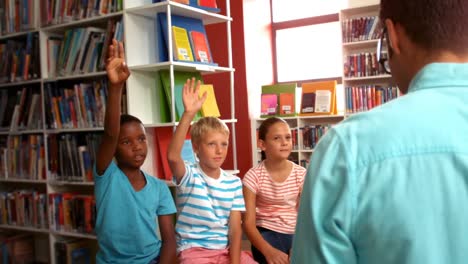 Niños-Levantando-La-Mano-En-La-Biblioteca