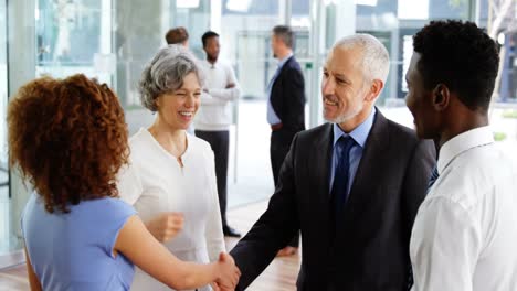 Businesspeople-shaking-hands-in-office