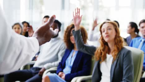 Businesspeople-raising-their-hands-during-a-meeting-