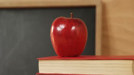 Close-up-of-books-stack-with-red-apple