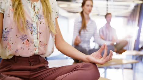 Gente-De-Negocios-Realizando-Yoga-En-La-Mesa