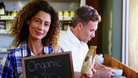 Woman-holding-a-board-that-reads-Organic-Coffee