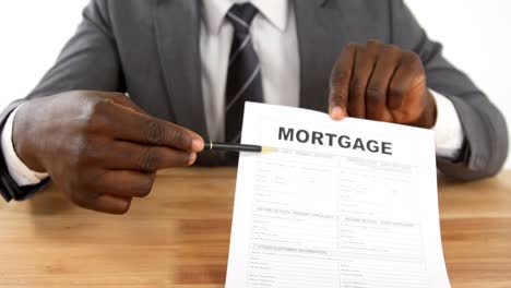 Agent-sitting-at-desk-holding-mortgage-contract