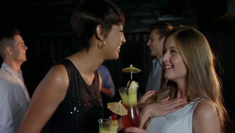 Beautiful-women-interacting-while-having-a-glass-of-cocktail-in-bar