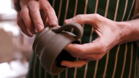 Mid-section-of-potter-making-cup