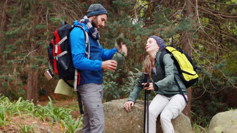 Hiker-couple-interacting-with-each-other-in-forest