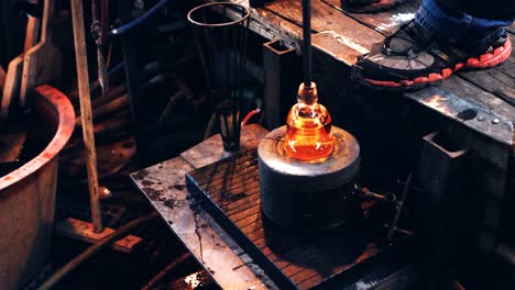 Glassblower-using-mold-to-shape-a-molten-glass