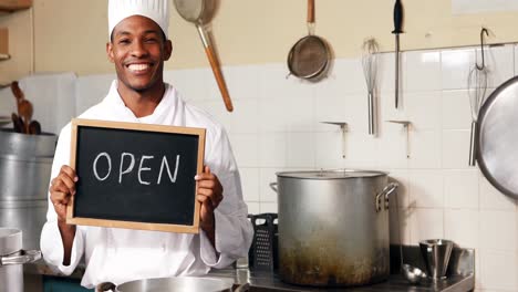 Chef-holding-showing-open-sign-with-chalkboard