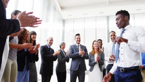 Businessman-dancing-while-his-colleagues-applauding-