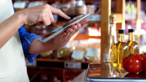 Female-staff-using-digital-tablet-in-supermarket