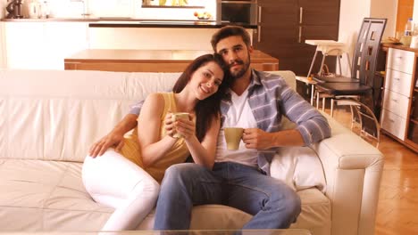 Couple-relaxing-on-sofa-and-having-coffee