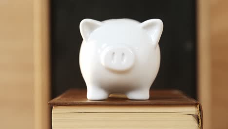 Close-up-of-books-stack-with-piggy-bank