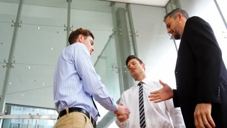Businessmen-shaking-hands-in-office