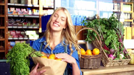 Portrait-of-smiling-woman-holding-a-grocery-bag-in-organic-section