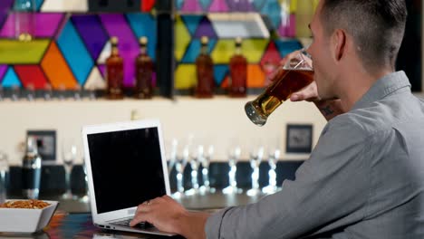 Mann-Benutzt-Laptop,-Während-Er-Ein-Bier-Trinkt