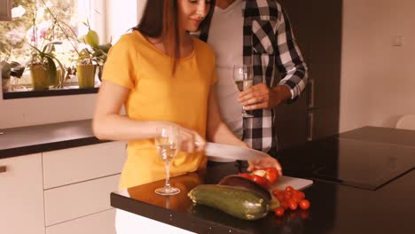 Woman-chopping-vegetable-while-man-having-champagne