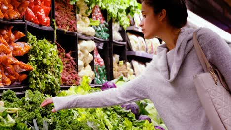Woman-buying-leafy-vegetables-in-organic-section