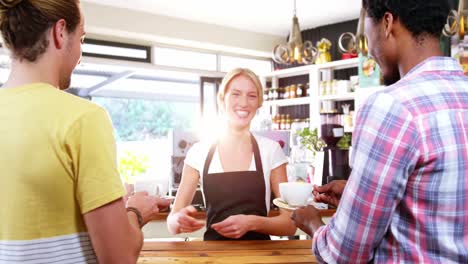 Smiling-waitress-serving-cup-of-coffee-to-customer