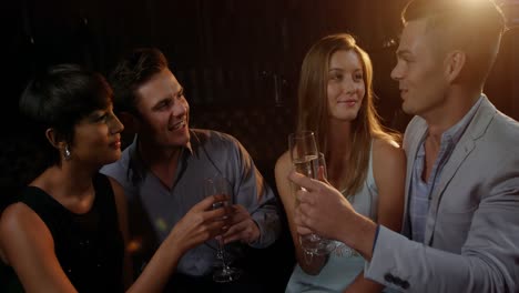 Group-of-smiling-friend-interacting-while-having-a-glass-of-champagne