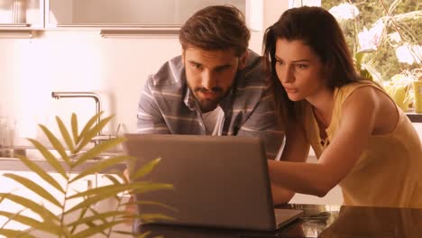 Couple-using-laptop-in-the-kitchen