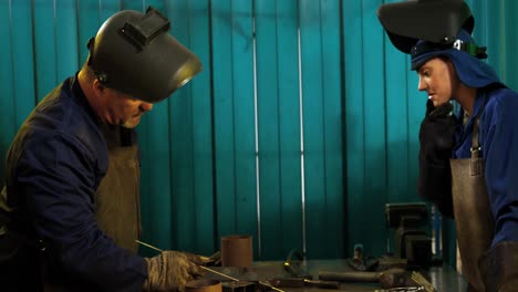 Female-welder-leaning-in-workshop