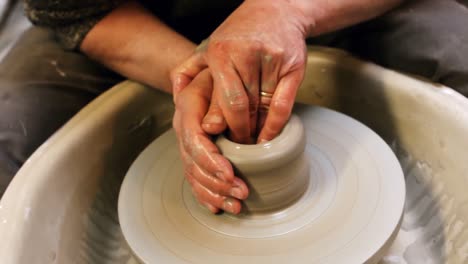 Mid-section-of-potter-making-pot