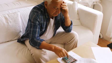 Tensed-senior-man-checking-the-bills
