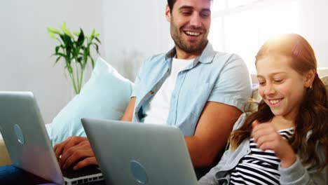 Father-and-daughter-using-laptop-in-the-living-room
