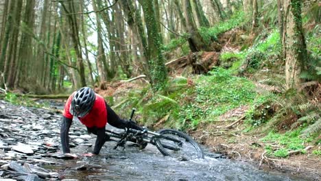 Mountain-biker-fallen-in-creek-while-riding-bicycle