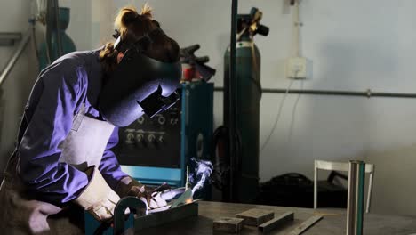 Female-welder-welding-a-metal