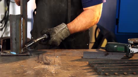 Welder-welding-a-metal-in-workshop