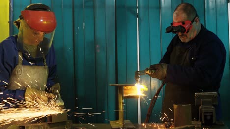 Male-and-female-welders-working-in-workshop