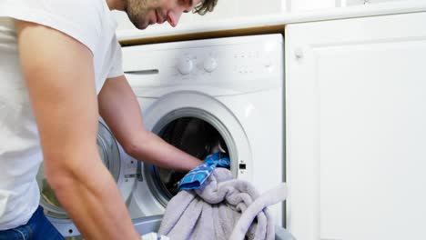 Man-putting-dirty-clothes-into-washing-machine