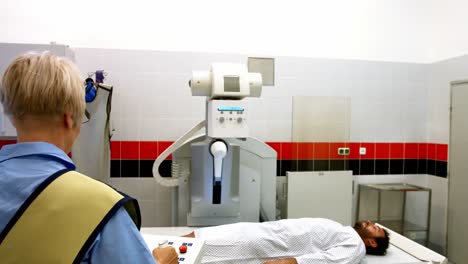 La-Doctora-Configura-La-Máquina-Para-Tomar-Rayos-X-A-Un-Paciente-Masculino.