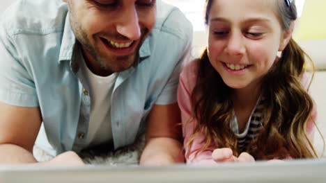 Father-and-daughter-using-digital-tablet-in-the-living-room