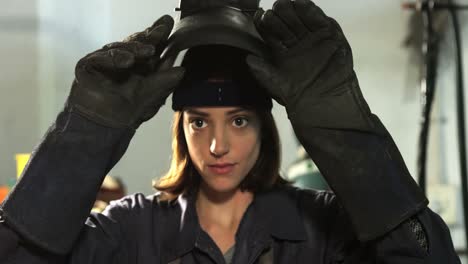 Female-welder-removing-helmet