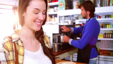 Beautiful-woman-holding-a-cup-of-coffee-at-counter