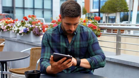 Businessman-using-digital-tablet-while-having-coffee