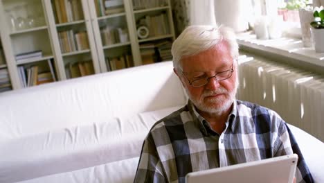 Älterer-Mann-Nutzt-Digitales-Tablet-Im-Wohnzimmer