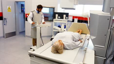 El-Médico-Masculino-Configura-La-Máquina-Para-Realizar-Una-Radiografía-A-Una-Paciente