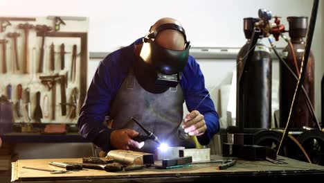 Male-welder-working-on-a-piece-of-metal