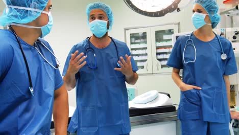 Cirujanos-Masculinos-Y-Femeninos-Interactuando-Entre-Sí-En-El-Quirófano
