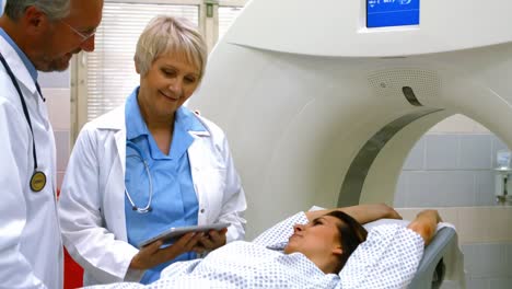 Doctors-explaining-diagnosis-to-female-patient-on-digital-tablet-before-mri-scan