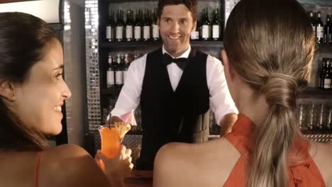 Waiter-serving-cocktail-to-customers