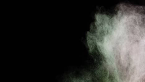 Green-and-red-dust-powder-blowing-against-black-background
