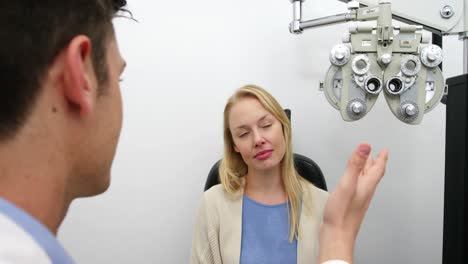 Optometrist-interacting-with-female-patient