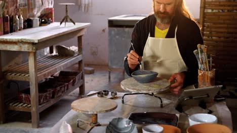 Attentive-male-potter-painting-on-bowl